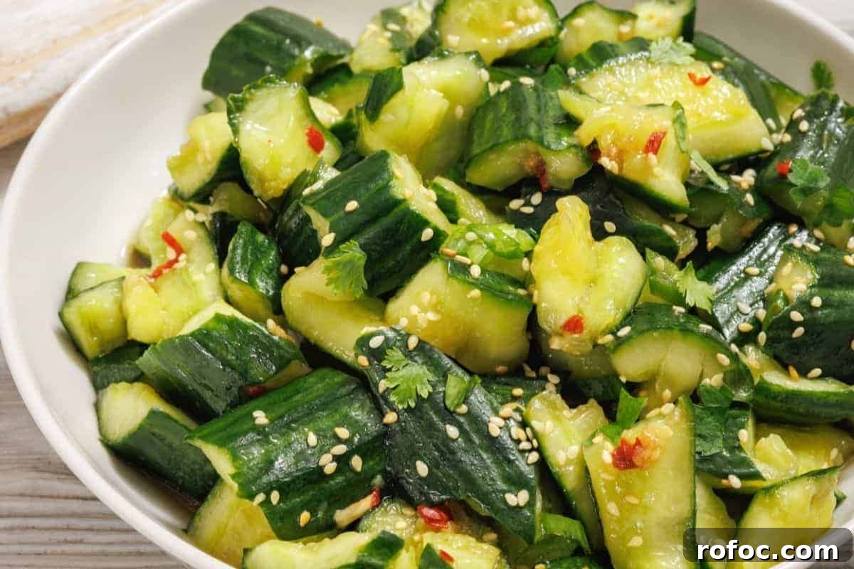 19 Fall Cookout Recipes for Sunday Dinner and Game Day 16 A bowl of smashed cucumber salad with sesame seeds, cilantro, red chili flakes, and a light dressing.