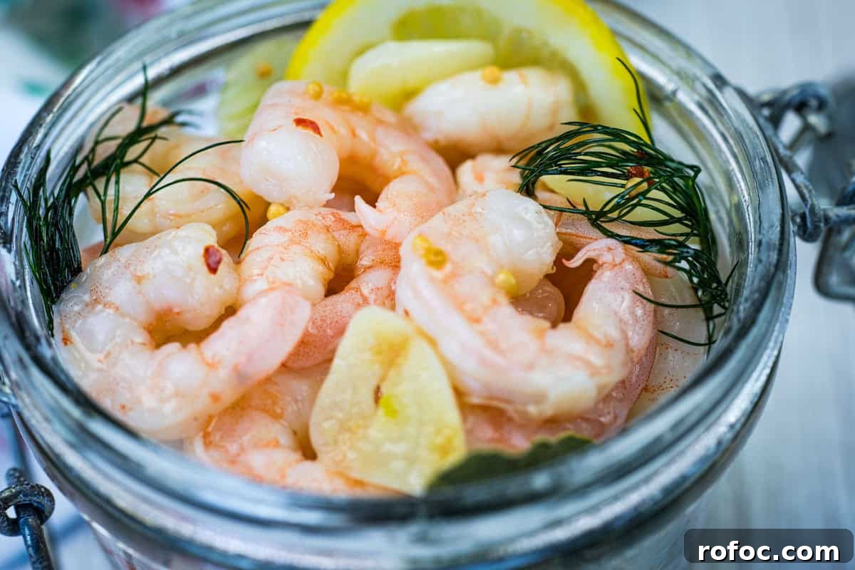 19 Fall Cookout Recipes for Sunday Dinner and Game Day 5 Close-up Southern Style Pickled Shrimp with lemon slices and dill on a jar.