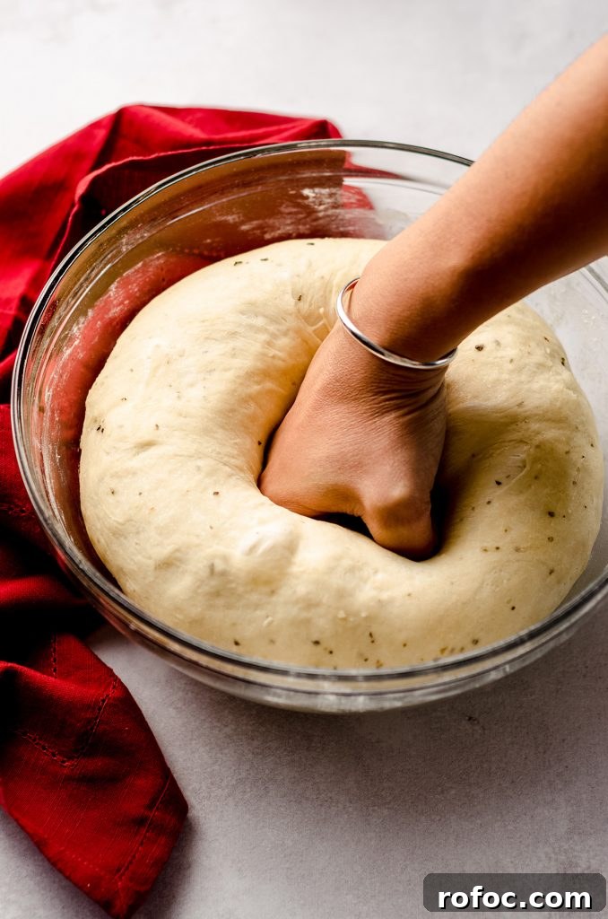 Baking with Yeast: A Practical Guide for Soft, Flavorful Bread 7 fist punching down pizza pull apart bread dough in a glass bowl