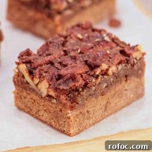 Derby Pie Brownies: Classic Kentucky Derby Dessert Recipe 15 Tableview of Derby pie brownie with chocolate chips and pecans on parchment paper - Kentucky Derby Pie Dessert - Hostess At Heart