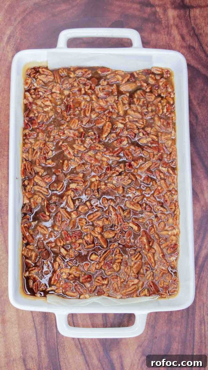 Derby Pie Brownies: Classic Kentucky Derby Dessert Recipe 10 9x13 baking dish with unbaked pecan praline topping a baked brownie ready for the oven