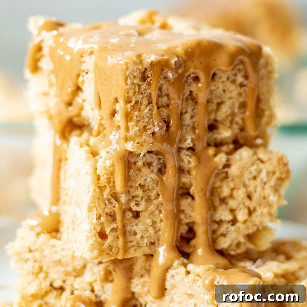 Peanut Butter Rice Krispie Treats Recipe You’ll Love 2 closeup of a stack of peanut butter rice krispie treats with melted peanut butter