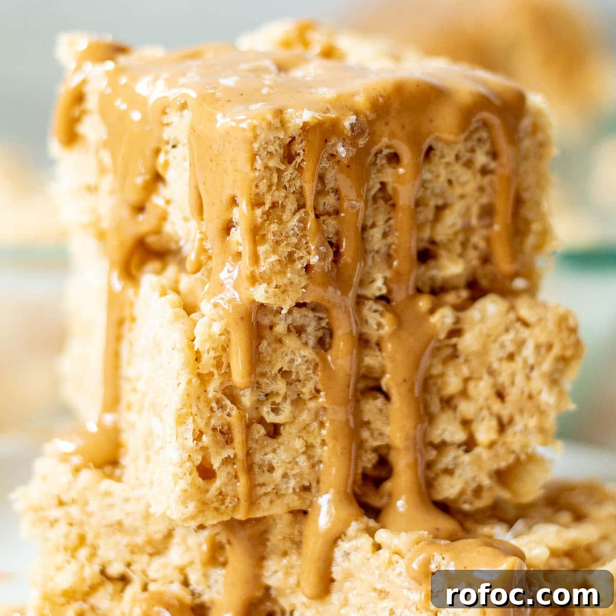 Peanut Butter Rice Krispie Treats Recipe You’ll Love 6 closeup of a stack of peanut butter rice krispie treats with melted peanut butter