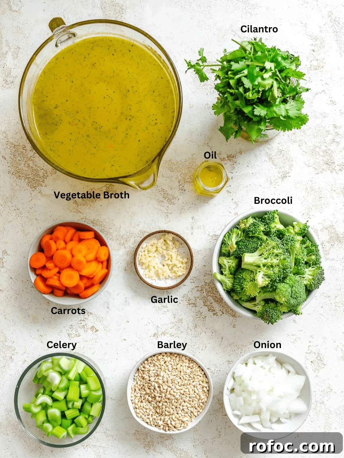 Hearty Vegetable and Barley Soup Recipe for Cozy Meals 3 Ingredients for Vegetable Barley Soup measured out on a white surface.