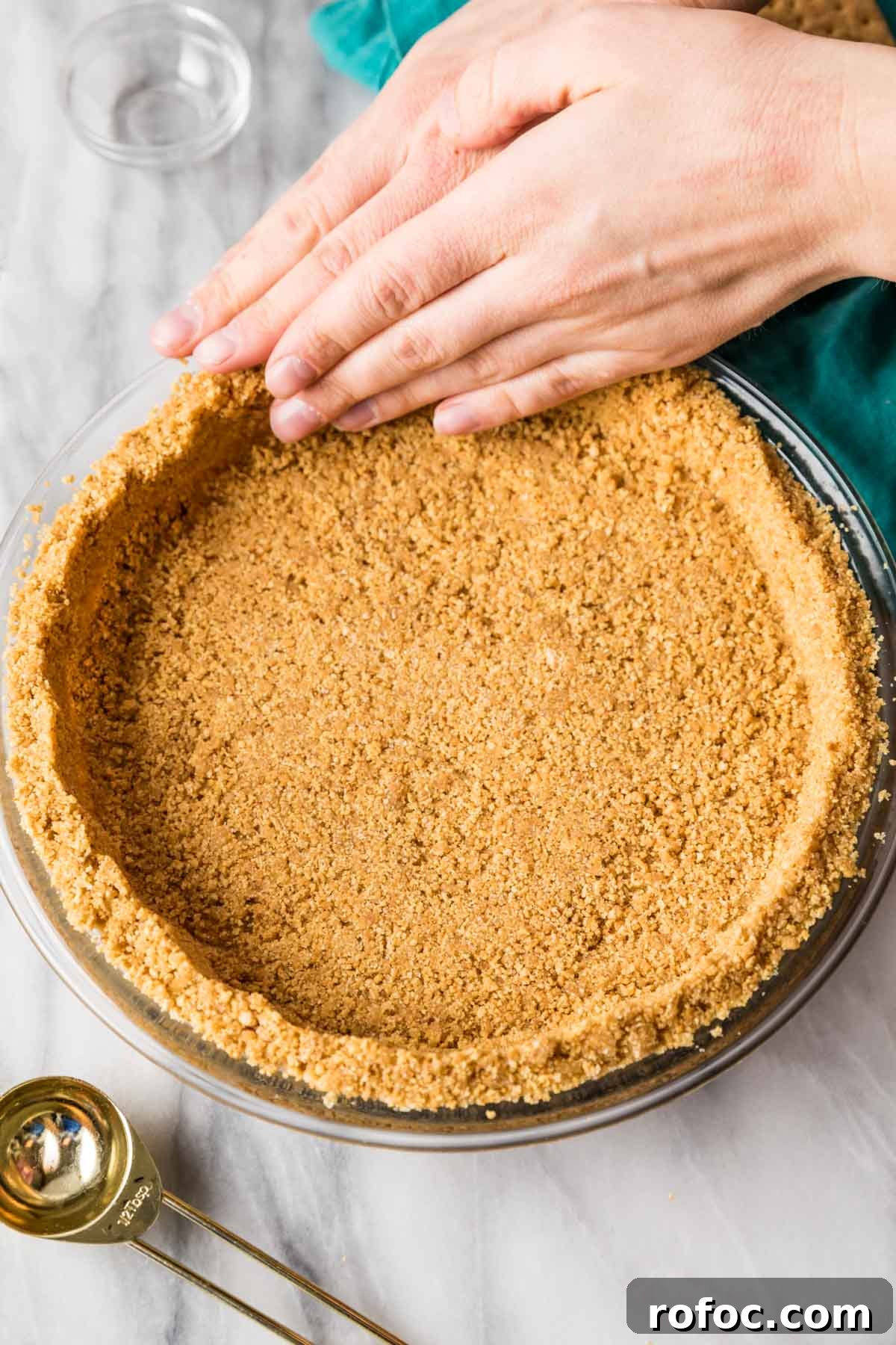Graham Cracker Crust Recipe: Simple Steps for Perfect Pie Crust 9 Pressing graham cracker crumbs into a glass pie plate.