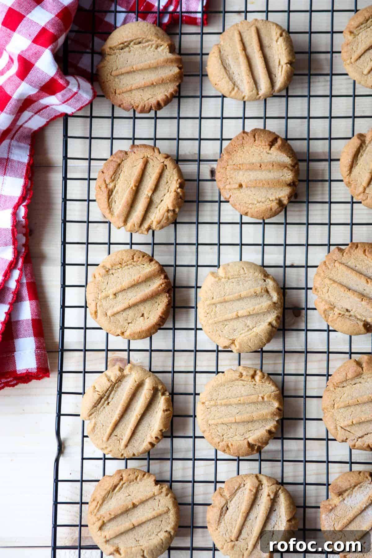A dozen peanut butter cookies cooling on a wire rack.
