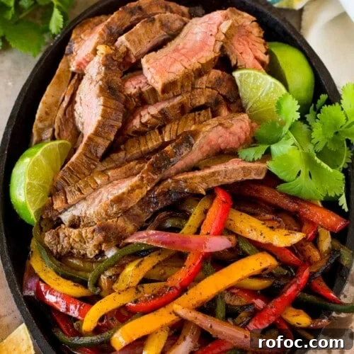 Steak fajita marinade coated meat and peppers in a cast iron pan.