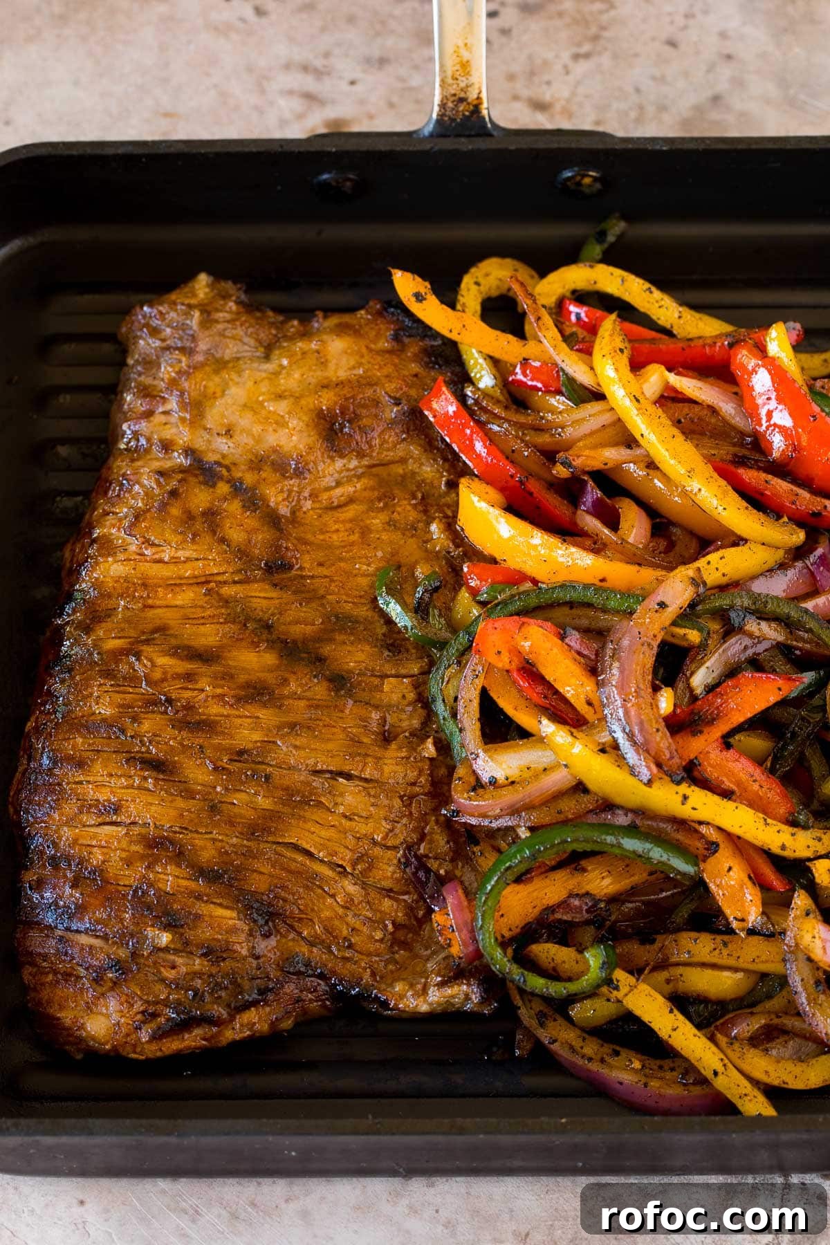 Flank steak and veggies cooked in a grill pan.