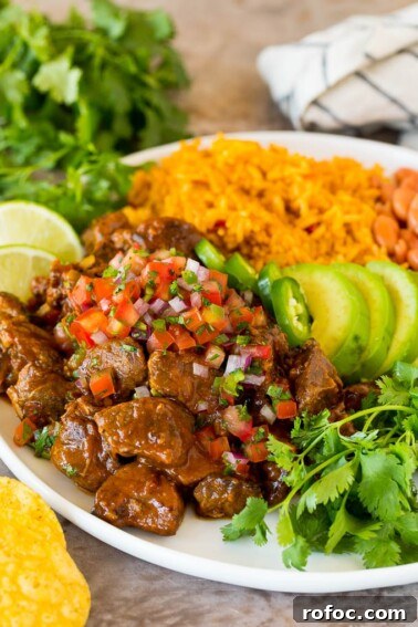 Carne guisada served with rice, beans and avocado.