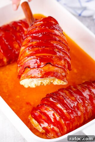 Very juicy and crispy bacon wrapped cream cheese stuffed chicken on a serving spatula.
