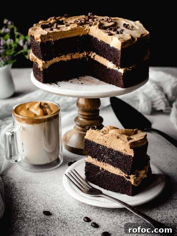 dalgona chocolate cake with slice on a plate in front and dalgona coffee to the side