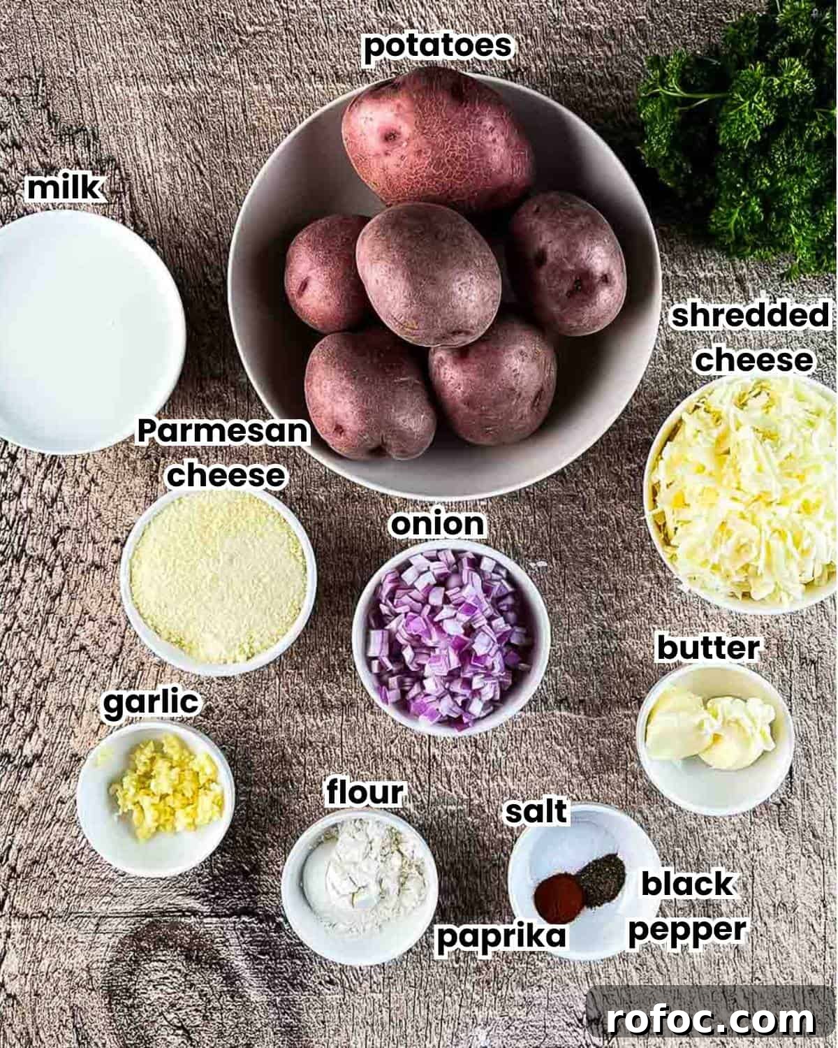 Ingredients for air fryer scalloped potatoes measured out, labeled, and placed on a wooden table.