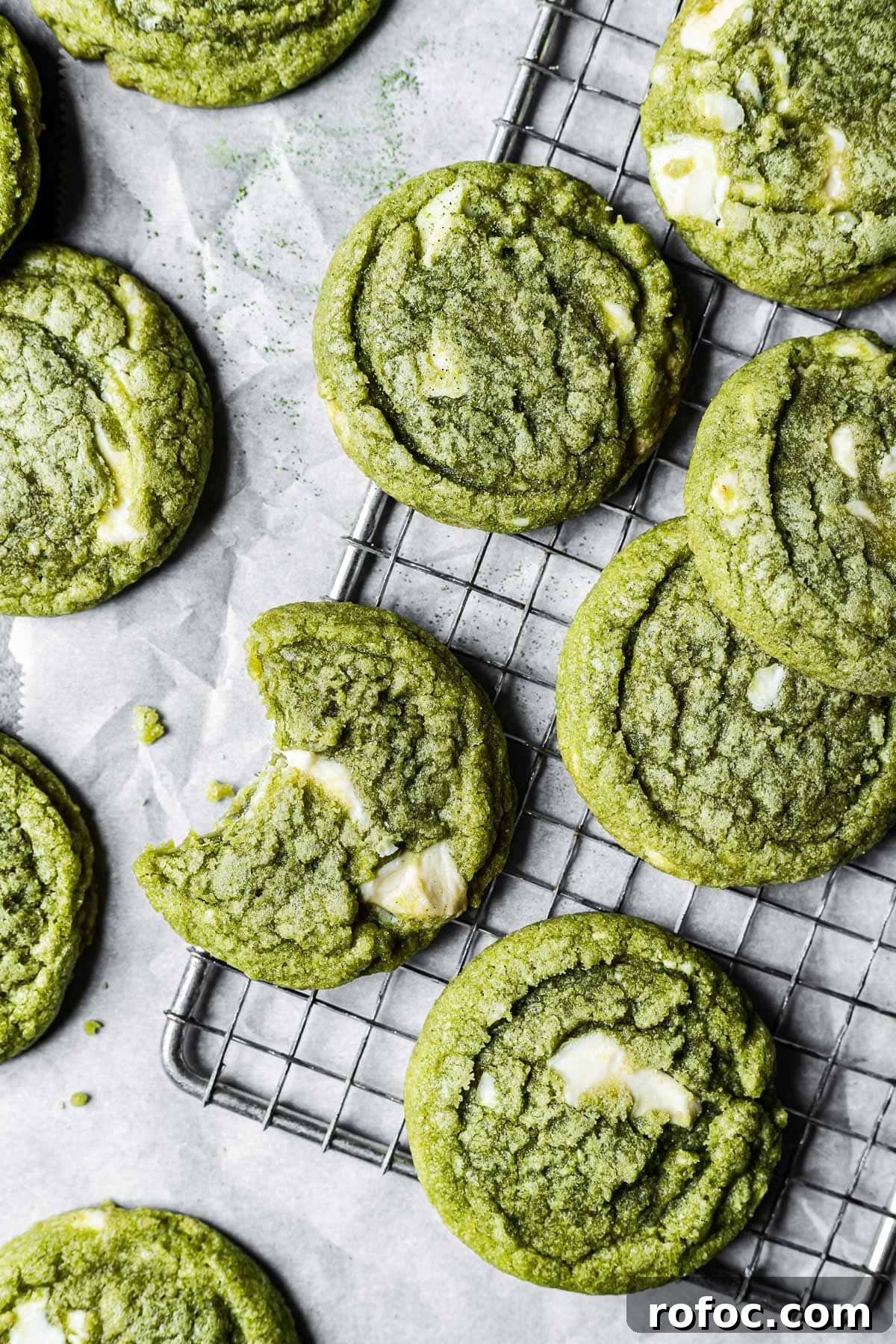 Matcha cookies on a metal wire cooling rack and white parchment paper.