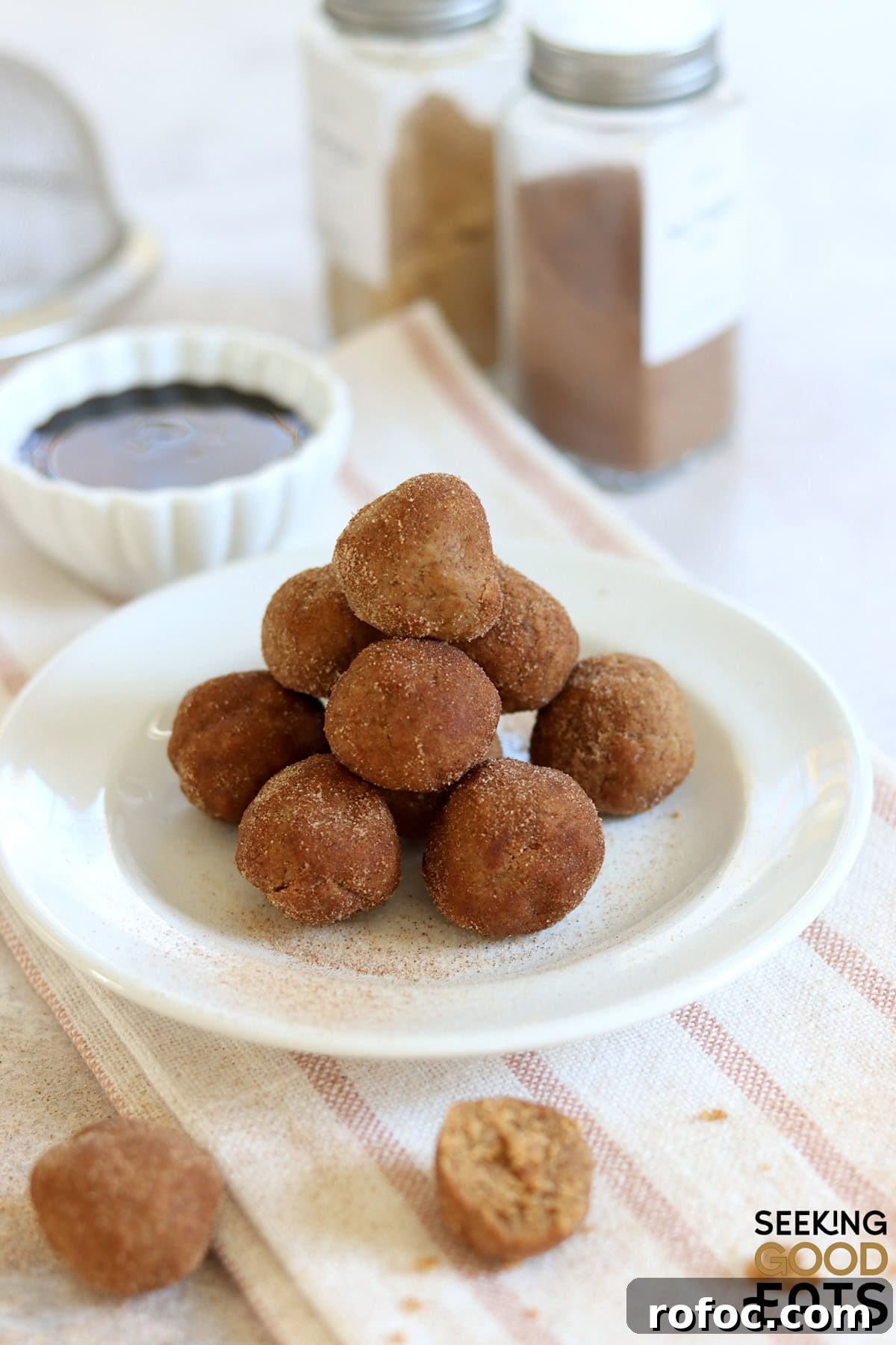 No bake gingerbread protein bites stacked on a white round plate.