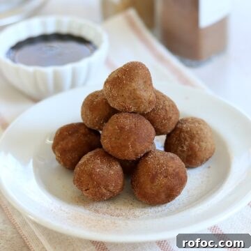 No bake gingerbread protein bites stacked on a white round plate.