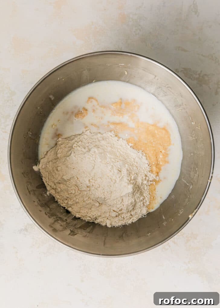 Mini Vanilla Cupcakes: Tender Bite-Sized Recipe 7 A silver bowl of butter, sugar, eggs, milk, and flour on a tan counter.