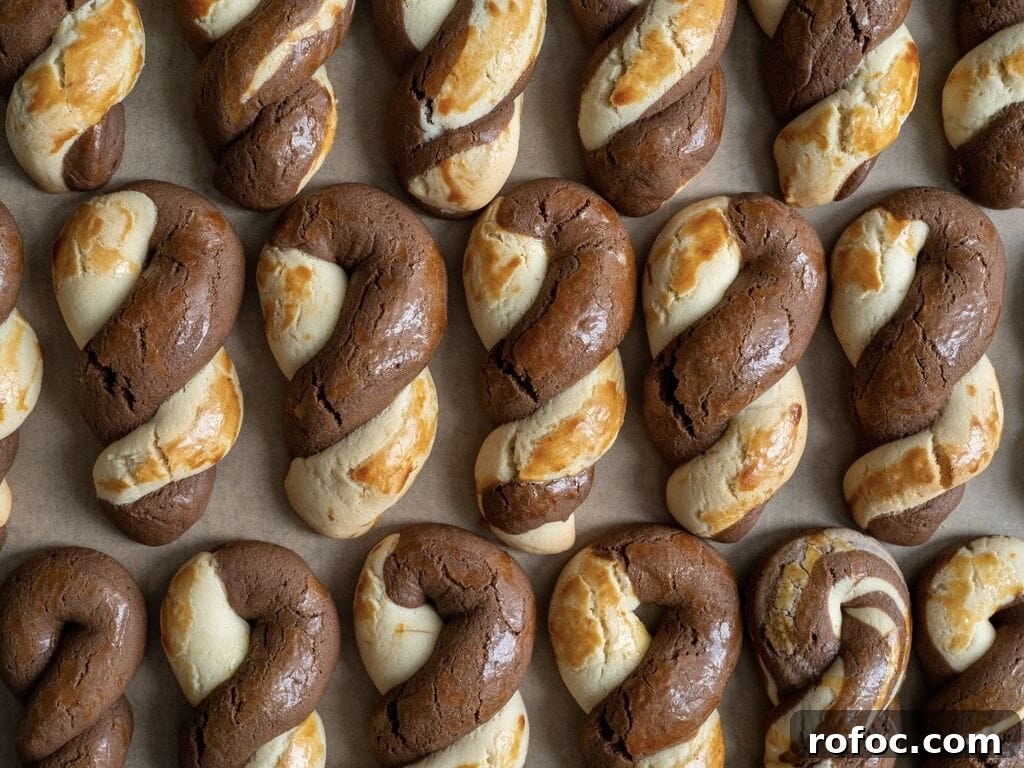 Greek butter koulourakia with a chocolate twist on a baking tray.