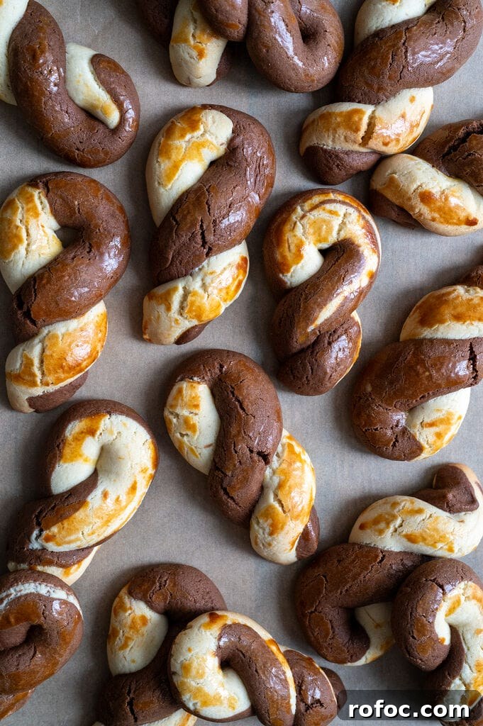 Greek butter koulourakia with a chocolate twist on a baking tray.