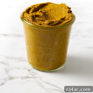 A glass jar filled with turmeric paste.