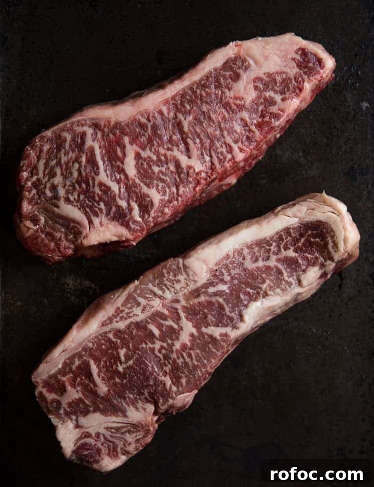 Two raw steaks with lots of marbling