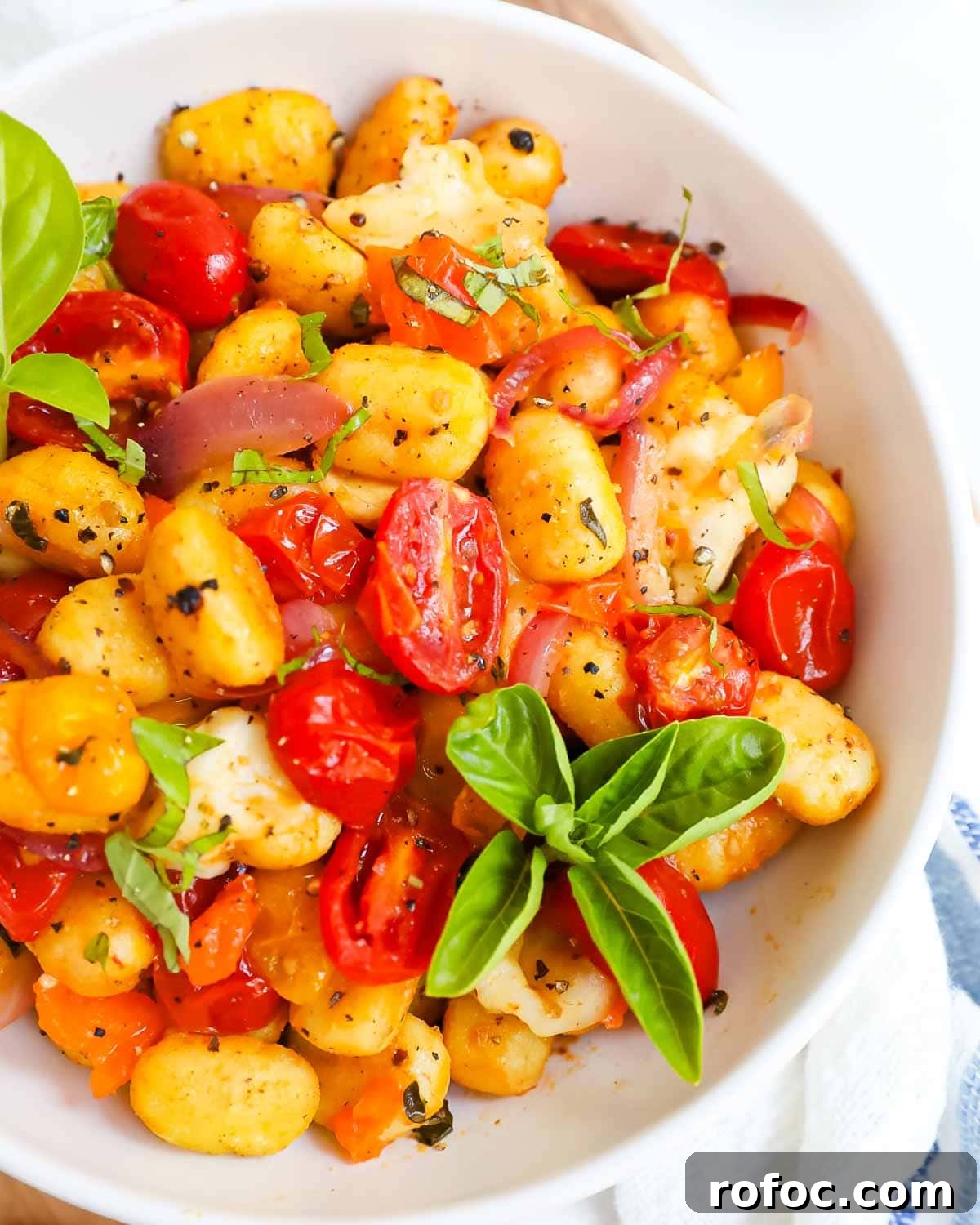 Crispy Sheet Pan Gnocchi with Roasted Vegetables 6 A close up picture of gnocchi and tomatoes in a bowl.